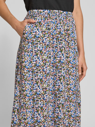 Frauenmodel trägt Ausgestellter Maxi-Rock aus reiner Viskose Modell 'EASY JOY' von Vero Moda im grafischen Allover-Muster, Nahaufnahme Oberkörper.