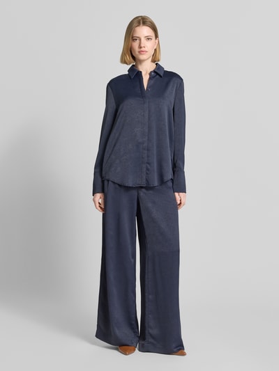 Modelka kobieca nosi Wide Fit Stoffhose mit Strukturmuster od Christian Berg Cocktail, granatowa, wzór kwiatowy, szerokie nogawki, tkanina z fakturą, zapięcie na zatrzask i zamek, szerokość w rozmiarze 36: 40 cm, długość nogawki wewnętrznej 80 cm, widok całej sylwetki od przodu.