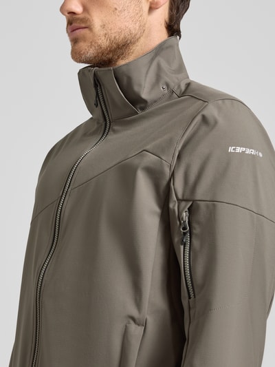 Männermodel trägt Regular fit heren jack met capuchon model 'BARMSTEDT' van Icepeak in bruin, opstaande kraag, mouwzak met ritssluiting, steekzakken, ritssluiting, logoprint, detailaufnahme bovenlichaam, context: ruglengte maat 50 78 cm, schouderbreedte 43 cm, borstwijdte 54 cm, mouwlengte 71 cm.