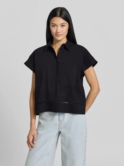Frauenmodel trägt Relaxed Fit Hemdbluse mit Loch-Stitching Modell 'Fallerie' von OPUS in Schwarz, kurzärmelig auf hellem Hintergrund, Nahaufnahme Oberkörper. Elastischer Baumwoll-Mix, Knopfleiste, Hemdblusenkragen, Rückenlänge bei Größe 36: 55 cm.