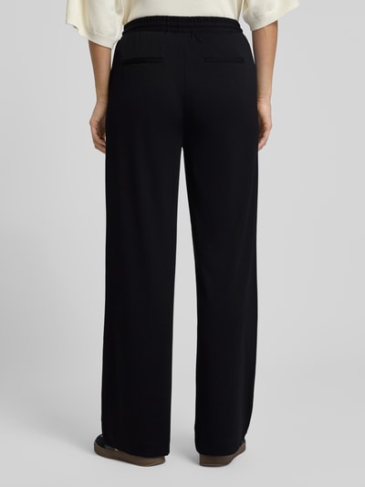 Frauenmodel trägt schwarze Stoffhose mit elastischem Bund Modell 'NANNI' von FREE/QUENT, lockerer Schnitt, Ganzkörperansicht Rückansicht.