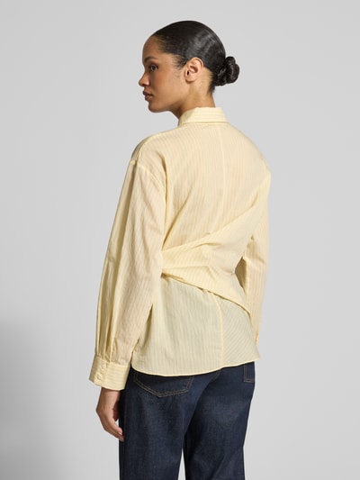 Frauenmodel trägt Regular Fit Bluse mit Knotendetail Modell 'CHIPITI' von Mango in zartgelb, Baumwoll-Mix, Rückansicht Ganzkörperansicht.
