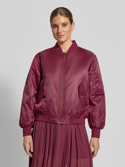 Vrouwenmodel draagt Bomberjacke aus reiner Baumwolle van Diesel in bessenrood met elastische boorden, zijzakken, zichtbare rits, losse fit, staande kraag, bovenlijf close-up voorkant, ruglengte 53 cm, borstwijdte 52 cm, mouwlengte 63 cm.