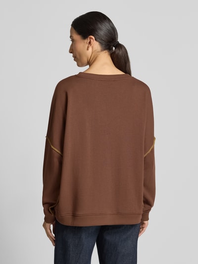Frauenmodel trägt Oversized Sweatshirt aus reiner Baumwolle Modell 'LOVE' von miss goodlife in Braun mit Rundhalsausschnitt, Statement-Print, Paillettenbesatz und Rippbündchen, Ganzkörperansicht Rückansicht.