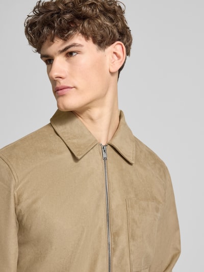 Männermodel trägt Regular Fit Jacke in Lederoptik Modell 'RICK' von Only & Sons in Beige, Umlegekragen, Reißverschluss, Nahaufnahme Oberkörper.