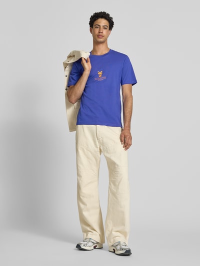 Männermodel trägt Herren T-Shirt von Jack & Jones in Blau mit Logo-Print, Reine Baumwolle, Regular-Fit, Rundhalsausschnitt, Modell 'Eres', Rückenlänge bei Größe M 68 cm, Ganzkörperansicht von vorne.