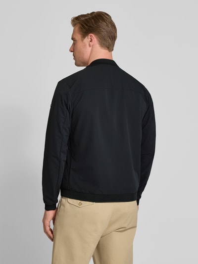Männermodel trägt schwarze Regular Fit Jacke mit Stehkragen Modell 'Campo' von SCANDINAVIAN EDITION, elastische Abschlüsse, Rückenlänge 67 cm, Schulterbreite 44 cm, Brustweite 51 cm, Ärmellänge 64 cm, Ganzkörperansicht Rückansicht.