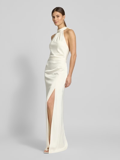 Frauenmodel trägt Regular Fit Abendkleid mit Raffungen von Jake*s Cocktail, Satin, Halterneck, Gehschlitz, cremefarben, Ganzkörperansicht von vorne.