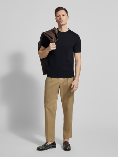 Männermodel trägt Slim Fit T-Shirt aus reiner Baumwolle von Profuomo, schwarz, kurzärmelig, Rundhalsausschnitt, Ganzkörperansicht von vorne.