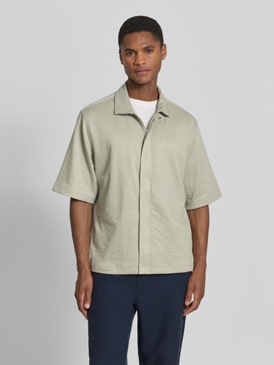 Männermodel trägt Regular Fit Freizeithemd mit verdecktem Reißverschluss von Lindbergh in hellem Beige, Baumwoll-Mix mit Stretch, Kentkragen, Struktur-Optik, vorne Ganzkörperansicht.