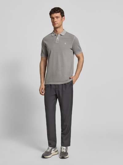 Männermodel trägt graues Poloshirt aus Baumwolle von MARC O’POLO DENIM mit Polokragen, Piqué, Logo, gerader Schnitt, Ganzkörperansicht von vorne.