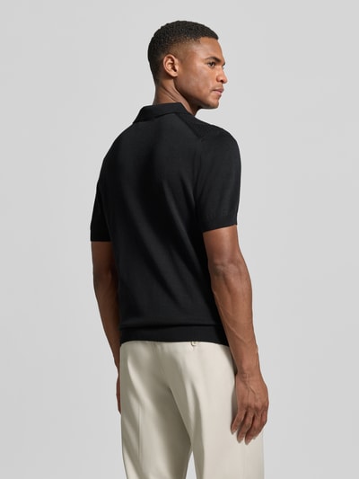 Männermodel trägt Regular Fit Poloshirt aus reiner Baumwolle von Strellson in Schwarz, Feinstrick, Strickoptik, Strukturmuster, Ganzkörperansicht Rückansicht.