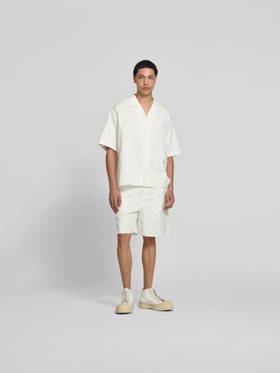 Männermodel trägt Freizeithemd mit Strukturmuster von Kenzo, reine Baumwolle, weiß, Relaxed Fit, Reverskragen, Ganzkörperansicht von vorne.