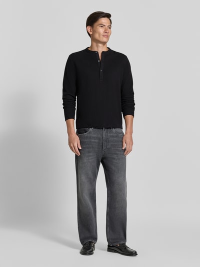Männermodel trägt Regular Fit Sweatshirt mit Baumwoll-Anteil Modell 'MALIOR' von DRYKORN in Schwarz, kombiniert mit Jeans, Ganzkörperansicht von vorne. Kontext: Material-Mix, Knopfverschluss, Rückenlänge bei Größe M 63 cm, Ärmellänge Größe M 69 cm.
