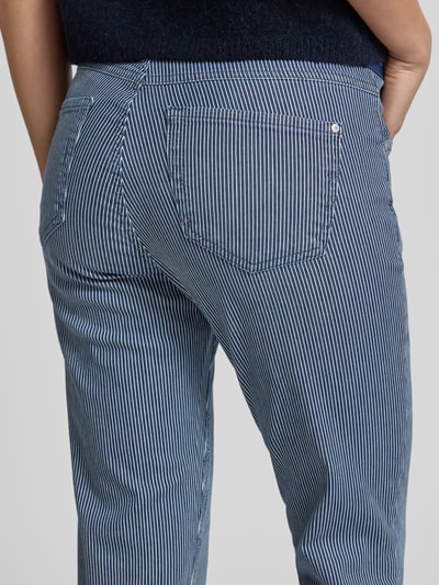 Kobieta nosi Slim Fit Jeans mit elastischem Bund Modell 'ORNELLA' von Angels, mieszanka bawełny z dodatkiem streczu, dopasowany krój, wpuszczane kieszenie, kieszeń z tyłu, szerokość w rozmiarze 36: 38 cm, długość wewnętrzna nogawki w rozmiarze 36: 67 cm, wzór w białe i niebieskie paski, widoczne tekstury tkaniny, detalaufnahme tyłu.