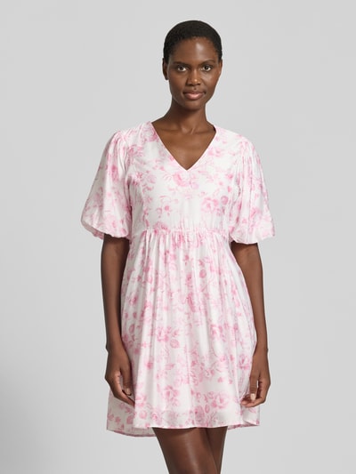 Frauenmodel trägt Tailliertes Freizeitkleid aus Viskose-Mix Modell 'BLISS' von Vero Moda mit Allover-Muster in Rosa-Weiß, feine Webstruktur, Ganzkörperansicht von vorne.