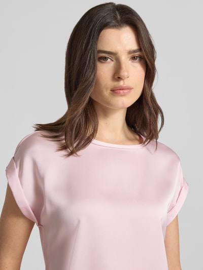 Vrouwenmodel draagt lichtroze T-shirt met ronde hals, los model, mix van viscose en elastaan, model 'ELLETTE' van Vila, nahaufnahme bovenlichaam. Ruglengte maat 36: 57 cm.