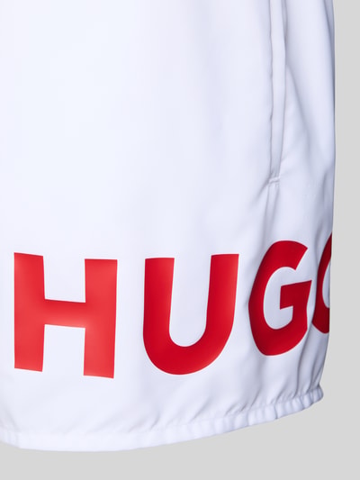 Produktfoto, Badeshorts mit Label Print Modell 'MAKAI' von HUGO in Weiß mit rotem Schriftzug, Popeline-Material, unifarbene Optik, Detailaufnahme