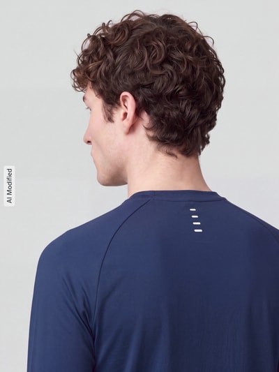Męski model nosi Regular Fit Sport-Langarmshirt mit Logo-Detail od Nike Training w kolorze granatowym, gładka tekstura, widok z tyłu, KI-modifiziertes Bild