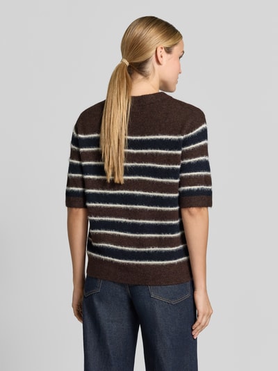Frauenmodel trägt Loose Fit Pullover mit Mohair-Woll-Anteil Modell 'Pimota Stripe' von OPUS in Braun mit weißen und dunkelblauen Streifen, lockere Strickstruktur, kurzarm, gerippter Bund, Ganzkörperansicht Rückansicht.