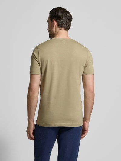 Męski model nosi T-Shirt mit Rundhalsausschnitt und Label-Stitching von Fynch-Hatton w kolorze beżowym, czysta bawełna, krój regular fit, okrągły dekolt, wyhaftowane logo, długość tyłu w rozmiarze M: 71 cm, całe ciało, widok z tyłu.
