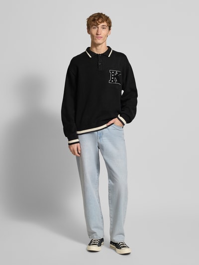 Mężczyzna nosi Strickpullover mit Polokragen und Stitching od KARL KANI, czarny, bawełniany krój regular fit, przód, zdjęcie całopostaciowe.