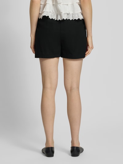 Frauenmodel trägt Relaxed Fit Bermudas aus Viskose-Leinen-Mix Modell 'JESMILO' von Vero Moda, Optik: Unifarben, Bundabschluss: Elastisch, seitliche Eingrifftaschen, Materialverarbeitung: Flammgarn, Ganzkörperansicht Rückansicht.
