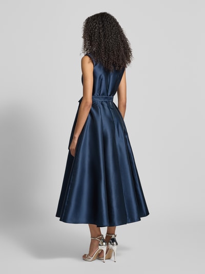 Frauenmodel trägt Cocktailkleid mit Reverskragen von Adrianna Papell in Dunkelblau mit Taillengürtel und Nahtreißverschluss, taillierter Schnitt, blickdichtes Unterkleid, Rückenlänge bei Größe 36: 38 cm, Brustweite bei Größe 36: 39 cm, Ganzkörperansicht Rückansicht.