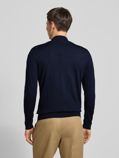 Männermodel trägt Cardigan mit Label-Detail Modell 'Balonso' von BOSS aus reiner Schurwolle, unifarben, Ganzkörperansicht Rückansicht.
