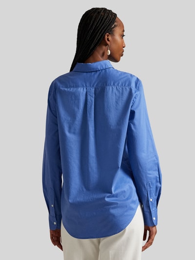 Frauenmodel trägt Slim Fit Hemdbluse aus reiner Baumwolle von Polo Ralph Lauren, efekt: jednolity kolor, krój slim fit, kołnierzyk koszulowy, pas na plecach z zakładką Cacharel, zapięcie: listwa guzikowa jednorzędowa, rękawy: długi rękaw, zakończenie: mankiet, wykończenie: dół zaokrąglony, materiał: bawełna, kolor niebieski, tekstura gładka. Ganzkörperansicht Rückansicht.