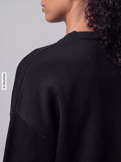 Frauenmodel trägt Regular Fit Strickjacke aus Viskose-Mix Modell 'NOELLA' von VERO MODA in Schwarz, Detailaufnahme, KI-modifiziertes Bild.
