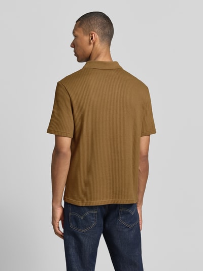 Männermodel trägt Modern Fit Polokragen mit kurzer Knopfleiste Modell 'JASE' von Samsøe Samsøe, reine Baumwolle, Strukturmuster, ganzkörperansicht Rückansicht.