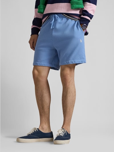 Męski model nosi Regular Fit Sweatshorts aus reiner Baumwolle von Polo Ralph Lauren, jednolity kolor, krój regular fit, wyhaftowane logo, tunel, elastyczny ściągacz, wpuszczane kieszenie, kieszeń z tyłu, dzianina dresowa, bawełna. Ujęcie: całe nogi z przodu.