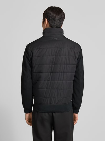 Männermodel draagt Jacke met opstaande kraag van Christian Berg Men, regular fit, ritssluiting en ritszakken, ribboorden, ruglengte maat M 26 cm, schouderbreedte 19 cm, borstwijdte 19 cm, mouwlengte 26 cm, zwart, textuur met doorgestikte naden, ganzekörperaanzicht achterkant.