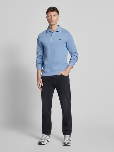Männermodel trägt Regular Fit Sweatshirt aus reiner Baumwolle von Lacoste, unifarben, Logo-Stitching, Polokragen, Rippenstruktur, Ganzkörperansicht von vorne.