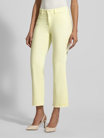 Kobiece modelka nosi Slim Fit Jeans mit Fransen od Marc Cain, bawełna z elastanem, krój slim fit, kieszenie, frędzle, szerokość w rozmiarze 36: 38 cm, długość nogawki od wewnątrz w rozmiarze 36: 70 cm, jasny żółty kolor, gładka tekstura, widok całościowy z przodu.