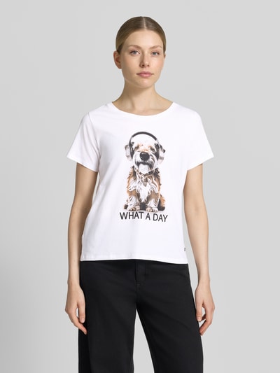 Frauenmodel trägt Regular Fit T-Shirt mit Ziersteinbesatz von monari, Baumwoll-Modal-Mix, Rundhalsausschnitt, Motiv-Print, Rückenlänge 54 cm, Ganzkörperansicht von vorne.