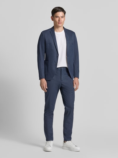 Männermodel trägt blaue Herren Anzughose mit Viskose-Anteil von s.Oliver BLACK LABEL vor grauem Hintergrund, Ganzkörperansicht von vorne.