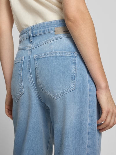 Frauenmodel trägt Barrel Fit Jeans mit Label-Detail Modell 'Blake' von Gang aus Baumwoll-Elasthan-Mix, Damen Jeans, Detailaufnahme Rückansicht, helle Farbe, sichtbare Eingrifftaschen, strukturierte Denim-Textur, Bundweite bei Größe 27: 40 cm, Innenbeinlänge bei Größe 27: 70 cm.