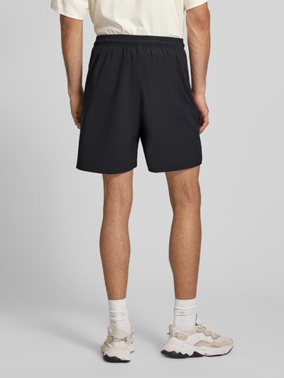 Männermodel trägt Regular Fit Shorts mit Tunnelzug von adidas Sportswear, Optik: Unifarben, Passform: Regular-Fit, Logo-Print, Kontraststreifen, elastischer Bundabschluss mit Tunnelzug, seitliche Eingrifftaschen, Ganzkörperansicht Rückansicht.
