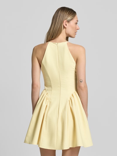 Frauenmodel trägt Cocktailkleid mit Schlüsselloch-Ausschnitt von Little Mistress in Gelb, A-Linie, Material-Mix mit Rayon-Anteil, Rückenreißverschluss, Minikleid, strukturierte Oberfläche, ganzkörperansicht Rückansicht. Kontext: Rückenlänge bei Größe 36: 83 cm, Brustweite: 40 cm.