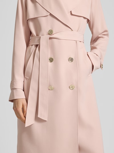 Vrouwenmodel draagt Zweireihiger Trenchcoat mit Bindegürtel van MICHAEL Michael Kors in lichtroze, regular fit, reverskraag, dubbele knopenrij, ceintuur, gladde textuur, detailopname van het bovenlichaam.
