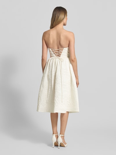 Frauenmodel trägt Minikleid mit floralem Allover-Stitching von Hey Kyla in Creme, schulterfrei, tailliert, ausgestellt, Ganzkörperansicht Rückansicht.