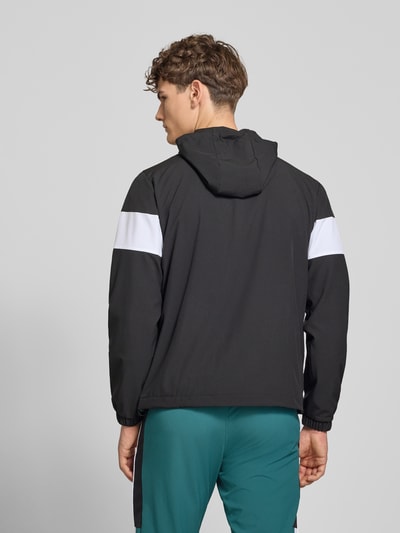 Männermodel trägt Regular Fit Jacke mit Logo-Stitching Modell 'Caspio' von SERGIO TACCHINI in Schwarz mit Weiß, Rückansicht, Ganzkörperansicht. Elastischer Material-Mix, Kapuze mit Tunnelzug, Reißverschluss, Eingrifftaschen, elastische Ärmelabschlüsse, Rückseite sichtbar.