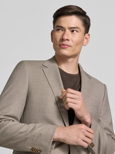 Männermodel trägt Slim Fit Anzug aus Schurwoll-Mix Modell 'HUGE' von BOSS in Beige, glatte Textur, Herren Anzug, Nahaufnahme Oberkörper.