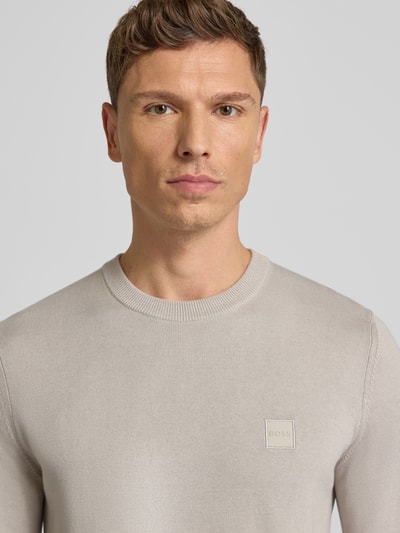 Männermodel draagt Regular Fit Pullover uit katoen-kasjmier-mix Model 'KANOVANO' van BOSS Oranje, effen look, labelpatch, ronde hals, lange mouw, gebreide structuur. Nahaufnahme bovenlichaam.