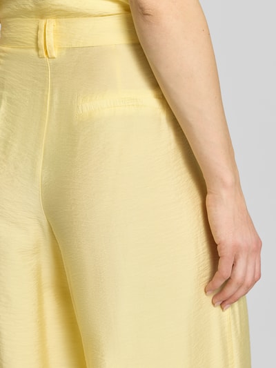 Vrouwenmodel draagt Wide Leg Pants aus Viskose-Mix mit Eingrifftaschen van GUIDO MARIA KRETSCHMER WOMAN in lichtgeel, detailopname heup en zak.