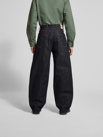 Männermodel trägt Wide Fit Jeans aus reiner Baumwolle von Kenzo, dunkles Blau, Kontrastnähte, 5-Pocket-Design, Ganzkörperansicht Rückansicht.