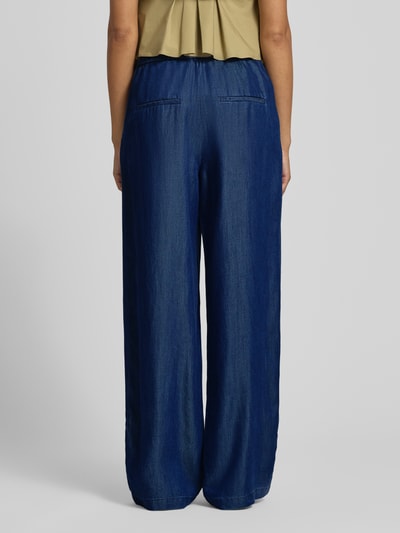 Männermodel trägt Wide Leg Jeans aus Lyocell von s.Oliver BLACK LABEL, jeansblau, Bundfalten, elastischer Bund, Ganzkörperansicht Rückansicht