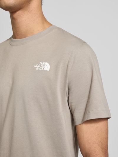 Männermodel trägt Regular Fit T-Shirt aus Baumwoll-Mix Modell 'EVOLUTION' von The North Face, Rundhalsausschnitt, Label-Detail, Nahaufnahme Oberkörper.